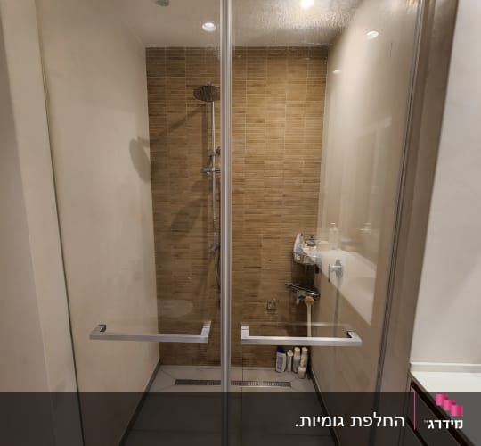 מקלחון חזית מזכוכית המותקן בין קירות בחדר רחצה